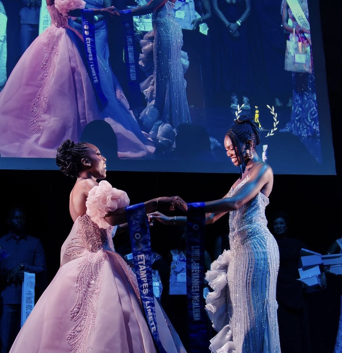 Deux candidates se tiennent les mains sur scène lors de la finale Miss RDC Diaspora France 2026
